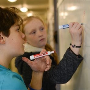 Students writing on a whiteboard