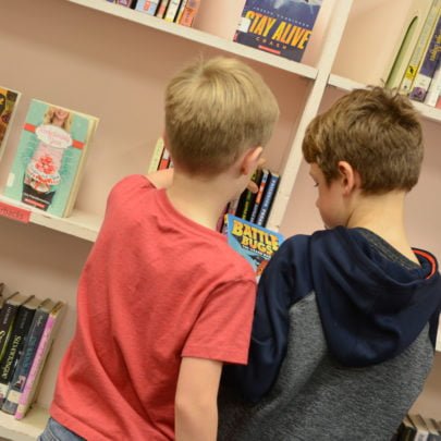 Two kids at a bookshelf